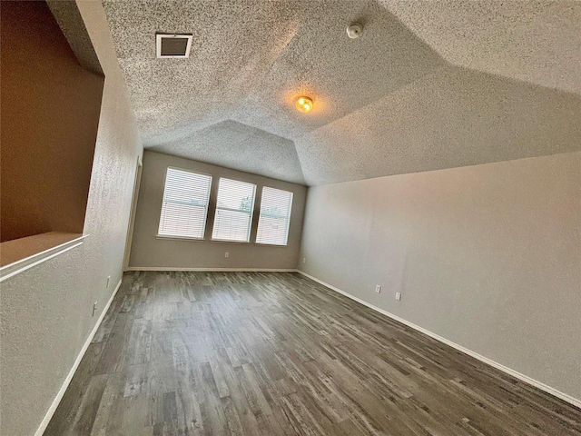 150 Wandering Dr, Forney, TX 75126 - additional living space with wood finished floors, lofted ceiling, and a textured wall