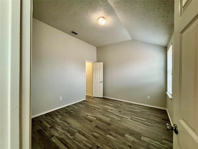150 Wandering Dr, Forney, TX 75126 - spare room featuring lofted ceiling, a textured ceiling, and dark wood-style floors
