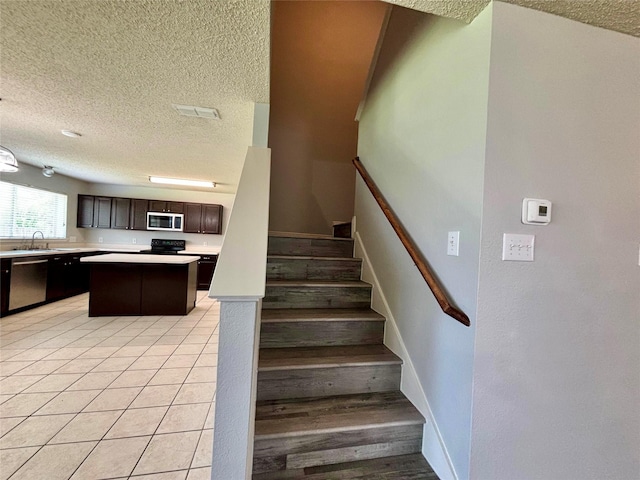 150 Wandering Dr, Forney, TX 75126 - stairway featuring a textured ceiling and tile patterned flooring