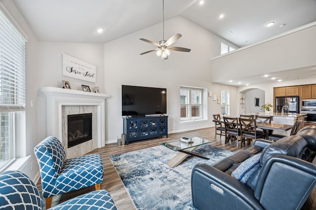 3915 Mercedes Bnd, Crandall, TX 75114 - living room featuring arched walkways, wood finished floors, a fireplace, a ceiling fan, and recessed lighting