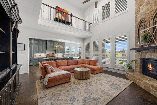 2223 Galloway Blvd, Trophy Club, TX 76262 - living area featuring a ceiling fan, a towering ceiling, dark wood finished floors, a stone fireplace, and a chandelier
