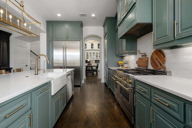 2223 Galloway Blvd, Trophy Club, TX 76262 - kitchen featuring green cabinets, premium appliances, arched walkways, light countertops, and dark wood-type flooring