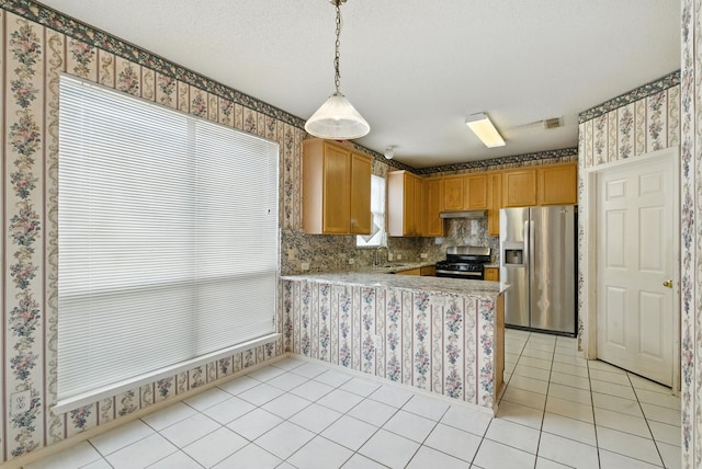 5004 Lodgepole Ln, Fort Worth, TX 76137 - kitchen featuring stainless steel fridge with ice dispenser, gas range oven, under cabinet range hood, light countertops, and a peninsula