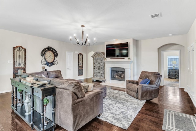 1402 White Water Ln, Rockwall, TX 75087 - living area featuring arched walkways, dark wood finished floors, a chandelier, and a fireplace with raised hearth