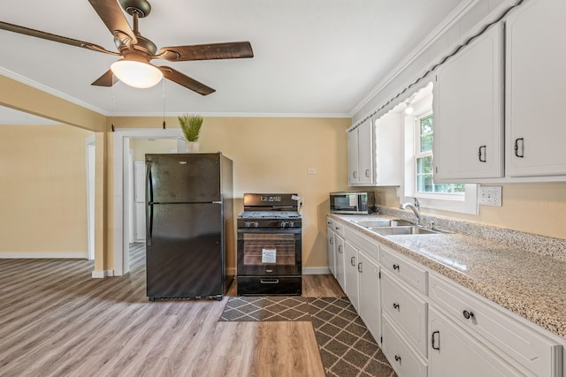 690 S Fifth Ave, Stephenville, TX 76401 - kitchen with black appliances, wood finished floors, ceiling fan, crown molding, and white cabinetry