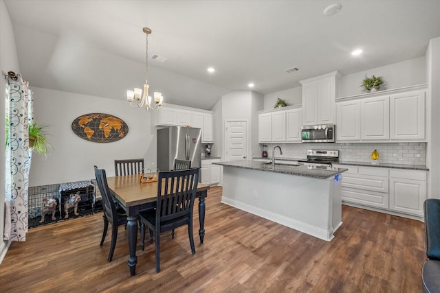 101 Paytons Way, Corsicana, TX 75110 - kitchen with stainless steel appliances, lofted ceiling, tasteful backsplash, a chandelier, and white cabinets