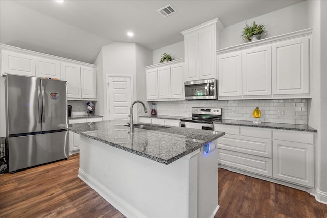 101 Paytons Way, Corsicana, TX 75110 - kitchen featuring appliances with stainless steel finishes, white cabinets, dark wood-type flooring, tasteful backsplash, and dark stone counters