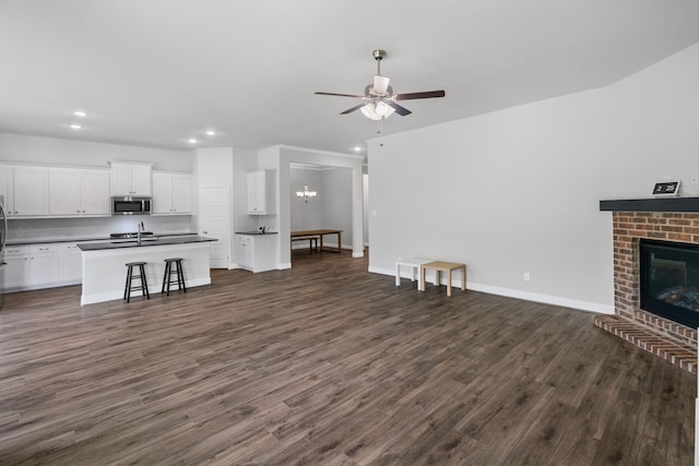 4919 Elizabeth Way, Lone Oak, TX 75453 - unfurnished living room with ceiling fan, recessed lighting, dark wood-style flooring, and a brick fireplace