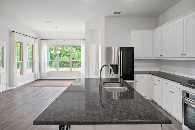 4919 Elizabeth Way, Lone Oak, TX 75453 - kitchen with appliances with stainless steel finishes, white cabinets, a center island with sink, wood finished floors, and a chandelier