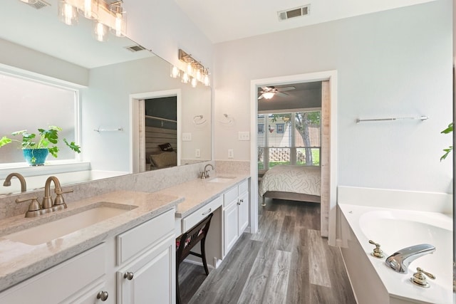 104 Northfield Cir, Hickory Creek, TX 75065 - ensuite bathroom featuring double vanity, wood finished floors, a bath, and ceiling fan