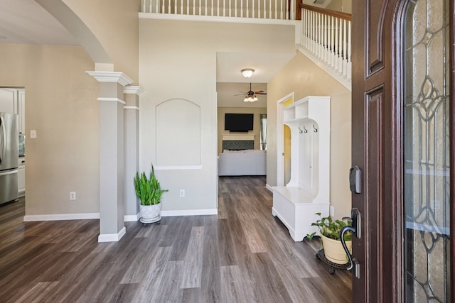 104 Northfield Cir, Hickory Creek, TX 75065 - entrance foyer with arched walkways, a ceiling fan, dark wood finished floors, a high ceiling, and decorative columns