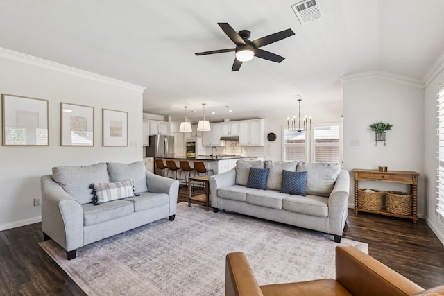 7716 Glenoaks Dr, Frisco, TX 75034 - living area featuring dark wood-style flooring, a ceiling fan, ornamental molding, and a chandelier