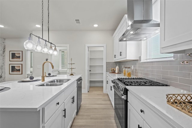5115 Hohen Ave, Dallas, TX 75215 - kitchen featuring wall chimney exhaust hood, stainless steel appliances, light wood-style floors, white cabinetry, and tasteful backsplash
