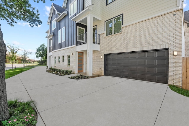5115 Hohen Ave, Dallas, TX 75215 - view of property exterior featuring brick siding, an attached garage, concrete driveway, board and batten siding, and a balcony