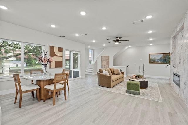 5115 Hohen Ave, Dallas, TX 75215 - living room featuring light wood-type flooring, ceiling fan, stairway, a tiled fireplace, and recessed lighting