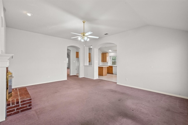 8709 Hartford Dr, Rowlett, TX 75089 - unfurnished living room featuring a ceiling fan, arched walkways, a fireplace, carpet, and lofted ceiling