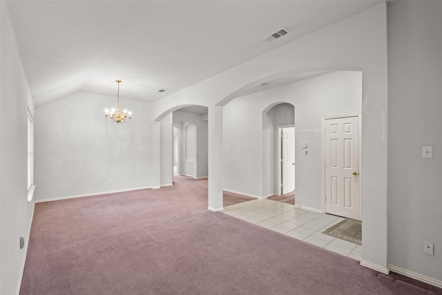 8709 Hartford Dr, Rowlett, TX 75089 - carpeted empty room featuring a chandelier, arched walkways, tile patterned floors, and vaulted ceiling