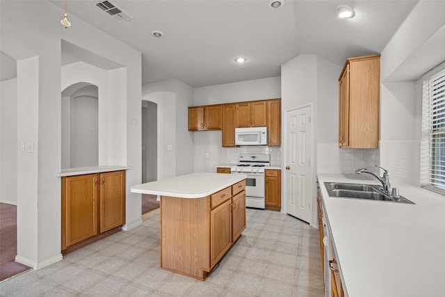 8709 Hartford Dr, Rowlett, TX 75089 - kitchen featuring white appliances, light countertops, a kitchen island, lofted ceiling, and arched walkways