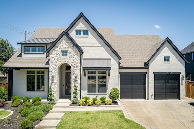 8990 Frostweed Rd, Frisco, TX 75035 - french country home featuring driveway, an attached garage, stone siding, roof with shingles, and a standing seam roof
