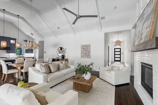 8990 Frostweed Rd, Frisco, TX 75035 - living area with dark wood-style flooring, ceiling fan, a fireplace, a chandelier, and beamed ceiling