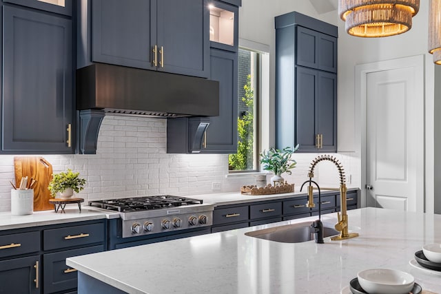 8990 Frostweed Rd, Frisco, TX 75035 - kitchen with stainless steel gas stovetop, decorative backsplash, extractor fan, light stone counters, and glass insert cabinets