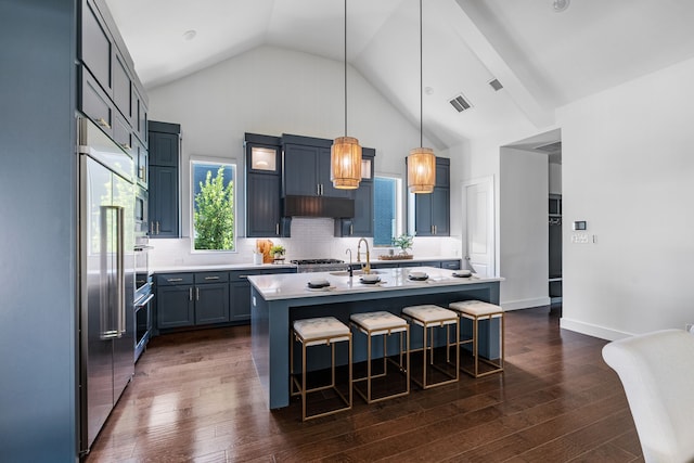 8990 Frostweed Rd, Frisco, TX 75035 - kitchen with a breakfast bar area, light countertops, dark wood finished floors, decorative backsplash, and an island with sink