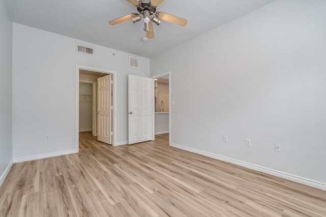 3102 Kings Rd Unit 2104, Dallas, TX 75219 - unfurnished bedroom with light wood-style floors, a walk in closet, a closet, and a ceiling fan
