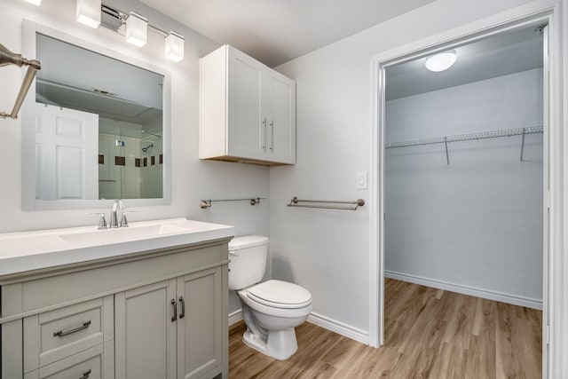 3102 Kings Rd Unit 2104, Dallas, TX 75219 - bathroom featuring wood finished floors, tiled shower, vanity, and a walk in closet