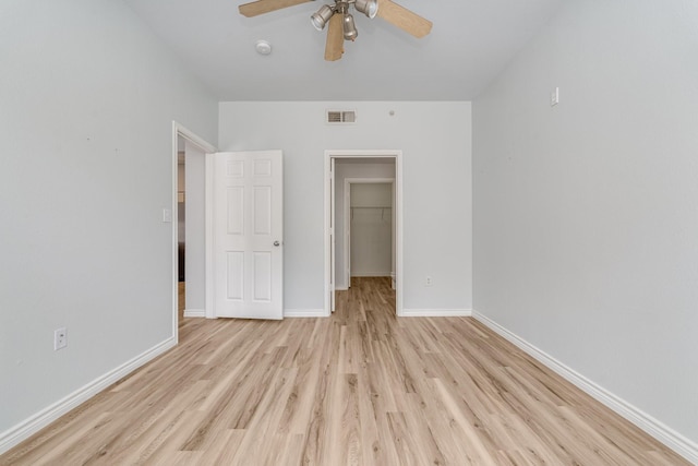 3102 Kings Rd Unit 2104, Dallas, TX 75219 - unfurnished bedroom with light wood-type flooring, a walk in closet, a closet, and ceiling fan