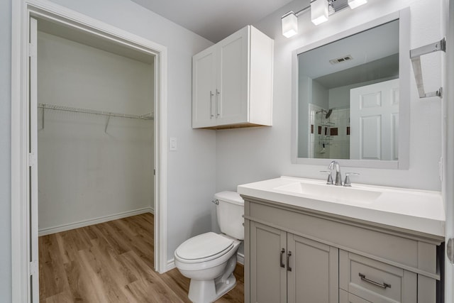 3102 Kings Rd Unit 2104, Dallas, TX 75219 - bathroom featuring wood finished floors, vanity, tiled shower, and a spacious closet