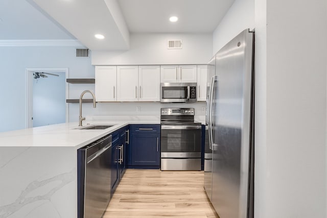 3102 Kings Rd Unit 2104, Dallas, TX 75219 - kitchen with stainless steel appliances, blue cabinets, crown molding, a peninsula, and light stone counters
