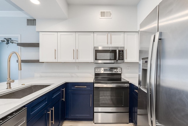 3102 Kings Rd Unit 2104, Dallas, TX 75219 - kitchen featuring appliances with stainless steel finishes, open shelves, white cabinets, light stone countertops, and blue cabinetry