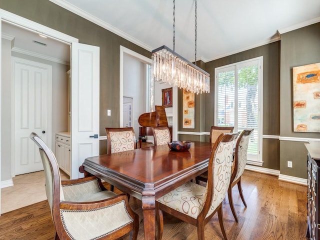 5909 Fossil Ridge Dr, Plano, TX 75093 - dining area with a chandelier, wood finished floors, and ornamental molding
