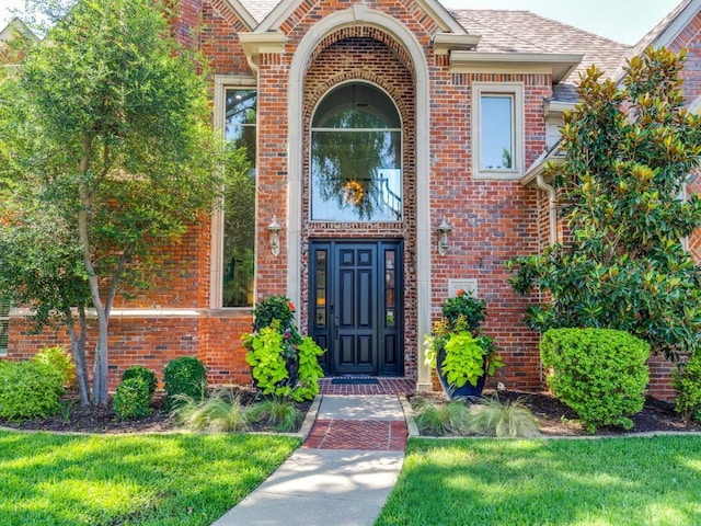 5909 Fossil Ridge Dr, Plano, TX 75093 - property entrance with brick siding, roof with shingles, and a lawn