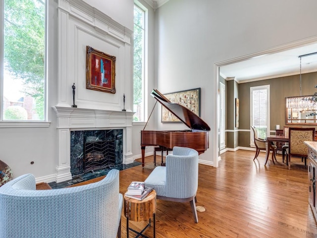 5909 Fossil Ridge Dr, Plano, TX 75093 - living room featuring light wood finished floors, a fireplace, crown molding, and a chandelier
