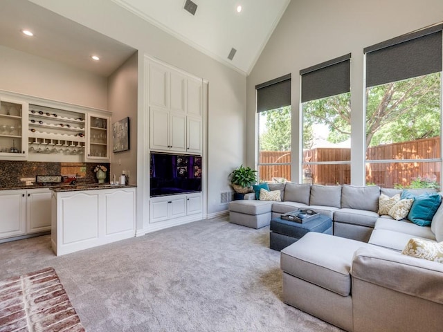5909 Fossil Ridge Dr, Plano, TX 75093 - living area featuring healthy amount of natural light, wet bar, light carpet, high vaulted ceiling, and recessed lighting