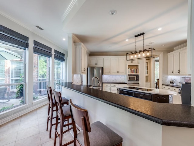 5909 Fossil Ridge Dr, Plano, TX 75093 - kitchen with stainless steel appliances, crown molding, a breakfast bar, decorative backsplash, and light tile patterned flooring