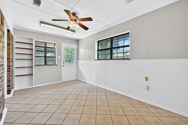 3214 N Marseille Ln, Sherman, TX 75090 - empty room featuring a ceiling fan, a wainscoted wall, and light tile patterned floors