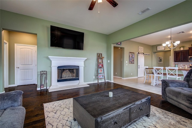 416 Mesa, Lone Oak, TX 75453 - living area with wood-type flooring, a ceiling fan, a fireplace with raised hearth, a chandelier, and a barn door