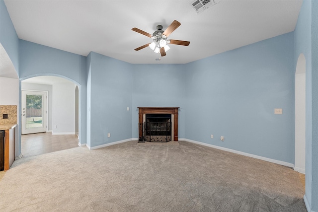 708 Sapphire Blvd, Hewitt, TX 76643 - unfurnished living room with arched walkways, light carpet, a ceiling fan, and a fireplace