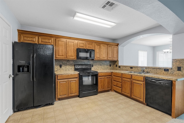708 Sapphire Blvd, Hewitt, TX 76643 - kitchen with black appliances, brown cabinets, arched walkways, and backsplash