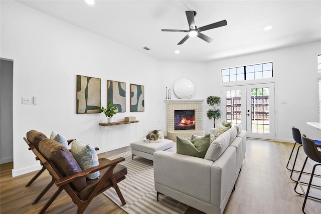 621 Drexel Dr, Grapevine, TX 76051 - living room with wood finished floors, a brick fireplace, recessed lighting, ceiling fan, and french doors