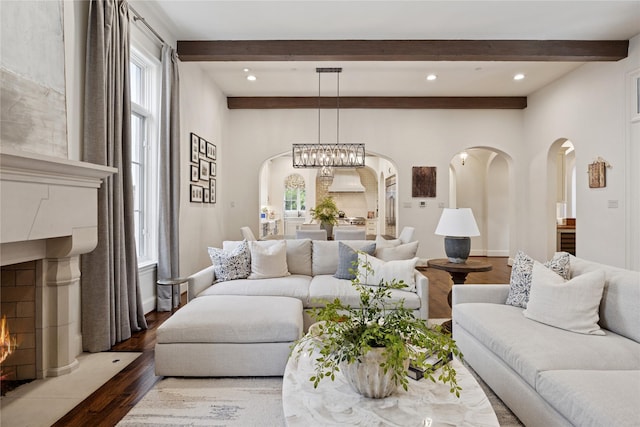 3404 Marquette St, University Park, TX 75225 - living area featuring arched walkways, dark wood-type flooring, beamed ceiling, a warm lit fireplace, and recessed lighting