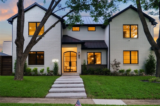 6716 Dalhart Ln, Dallas, TX 75214 - modern inspired farmhouse featuring a standing seam roof, a yard, and brick siding