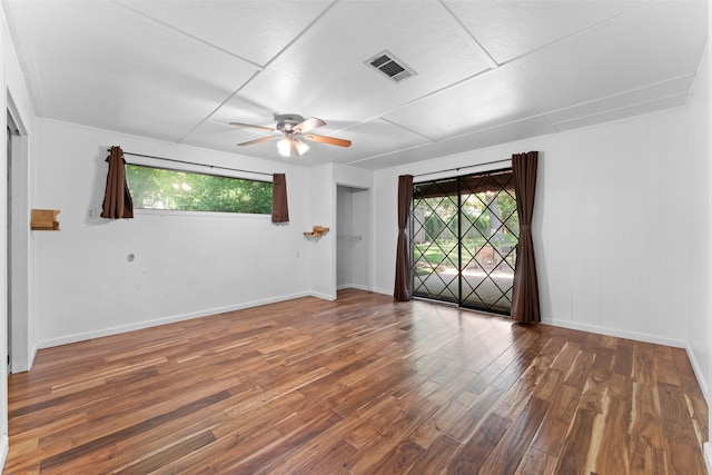 1227 N Irving Heights Dr, Irving, TX 75061 - empty room with healthy amount of natural light, a ceiling fan, and wood finished floors