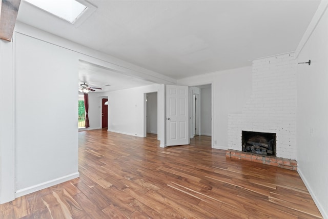 1227 N Irving Heights Dr, Irving, TX 75061 - unfurnished living room with wood finished floors, a fireplace, a skylight, and ceiling fan