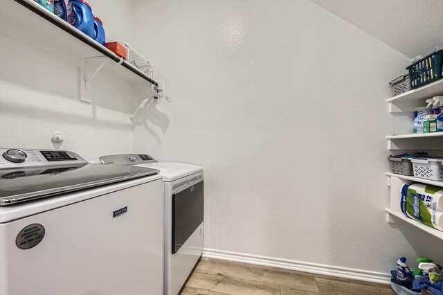 8009 Gangway Dr, Fort Worth, TX 76179 - laundry room with independent washer and dryer and light wood-style flooring