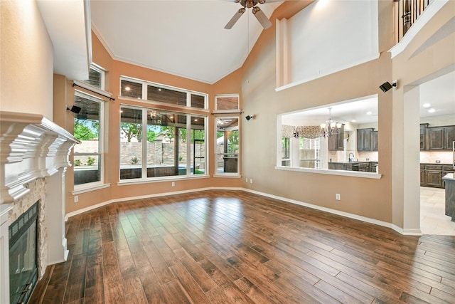 2908 Carterton Ct, Flower Mound, TX 75022 - unfurnished living room with a glass covered fireplace, ceiling fan, hardwood / wood-style floors, a chandelier, and high vaulted ceiling
