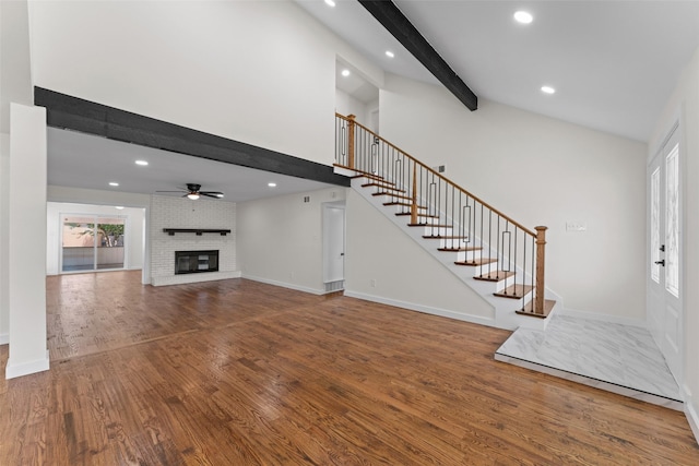 1315 Dunbarton Dr, Richardson, TX 75081 - unfurnished living room featuring beam ceiling, stairway, wood finished floors, a ceiling fan, and a fireplace