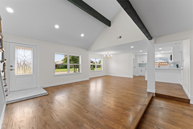 1315 Dunbarton Dr, Richardson, TX 75081 - unfurnished living room featuring beamed ceiling, a chandelier, wood finished floors, recessed lighting, and high vaulted ceiling